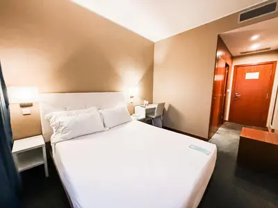 a hotel room with a large white bed and a door at Stay Hotel Porto Centro Antas in Porto