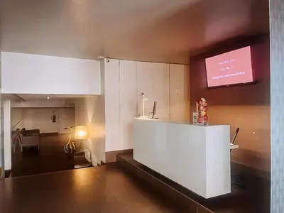 a kitchen with white cabinets and a tv on the wall at Stay Hotel Porto Centro Antas in Porto