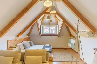 a attic bedroom with a bed and a couch at Shining View Apartments in Porto