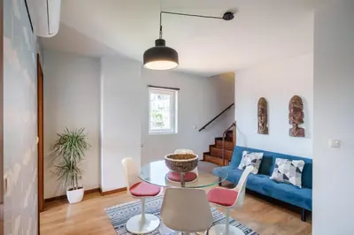 a living room with a table and chairs and a blue couch at Shining View Apartments in Porto