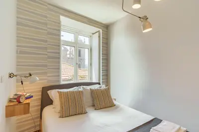 a bedroom with a bed with two pillows and a window at Shining View Apartments in Porto