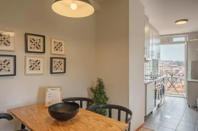 a kitchen and dining room with a wooden table and chairs at Shining View Apartments in Porto