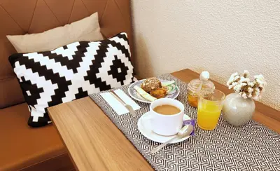 a table with a plate of food and a cup of coffee at The Rex Hotel Porto - Mansion House - Private Parking in Porto