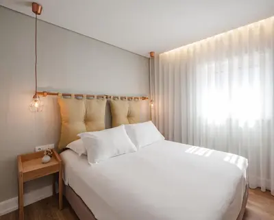 a bedroom with a large white bed and a window at The Rex Hotel Porto - Mansion House - Private Parking in Porto