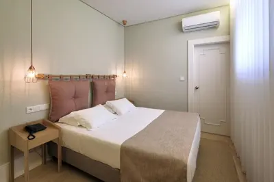 a small bedroom with a bed and a night stand at The Rex Hotel Porto - Mansion House - Private Parking in Porto