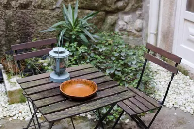 a wooden table with a bowl and a lamp on it at Cale Guest House in Porto