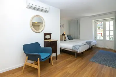 a bedroom with a bed and a chair and a mirror at Historical Center - Taipas Apartments in Porto