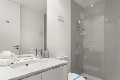 a white bathroom with a sink and a shower at Historical Center - Taipas Apartments in Porto