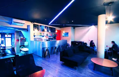 a room with a bar and people sitting at a counter at PILOT Design Hostel & Bar in Porto
