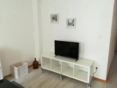 a flat screen tv sitting on a white entertainment center at Kris Apartments Porto in Porto