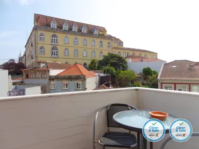 a table and chair on a balcony with a building at RS Porto Vilar in Porto