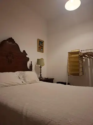 a bedroom with a large bed with a desk and a chair at Grandmotherhouse 2-7 Pax in Porto