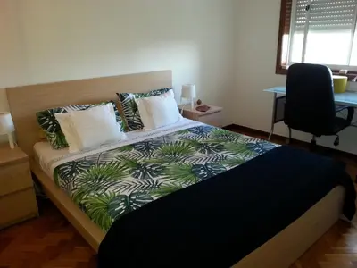 a bedroom with a bed and a desk and a window at Grandmotherhouse 2-7 Pax in Porto