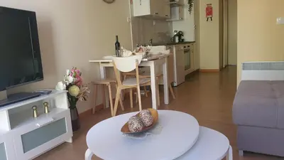 a living room with a kitchen and a table with a cake on it at Downtown Porto with PARKING next to subway in Porto
