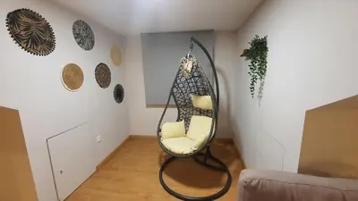 a living room with a chair and a mirror at Downtown Porto with PARKING next to subway in Porto