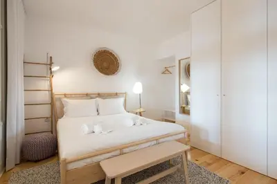 a bedroom with a white bed and a table at LovelyStay - Martires Boutique Flat in Porto