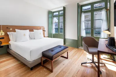 a bedroom with a large white bed and a desk at One Shot Aliados Goldsmith in Porto