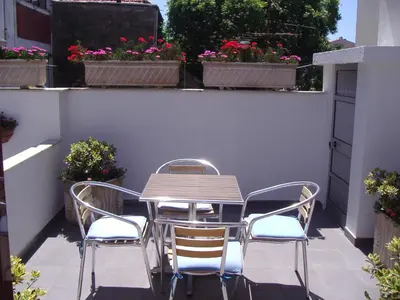 a table and chairs on a balcony with flowers at Hotel Grande Rio in Porto