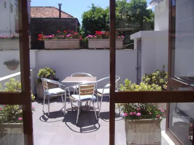 a patio with a table and chairs and flowers at Hotel Grande Rio in Porto