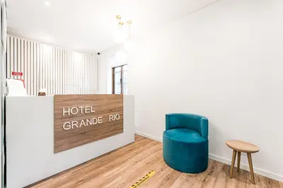 a blue chair sitting in a room with a sign at Hotel Grande Rio in Porto