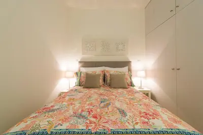 a bedroom with a large bed with two lamps at BmyGuest - Villa Lóios Terrace Apartment in Porto