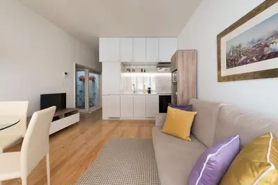 a living room with a couch and a table and a kitchen at BmyGuest - Villa Lóios Terrace Apartment in Porto