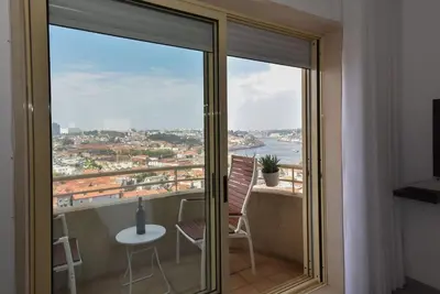 a balcony with a table and chairs and a view at Porto Gaia River View 8 by MP in Vila Nova de Gaia