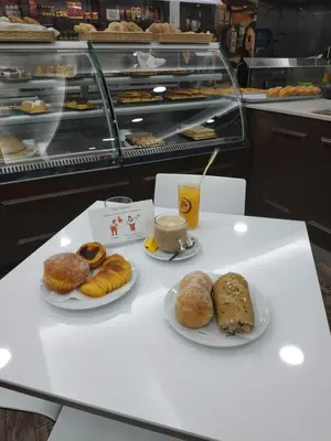a table with two plates of pastries and a cup of coffee at Porto Gaia River View 8 by MP in Vila Nova de Gaia