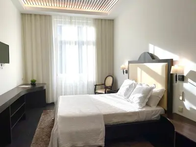a bedroom with a bed with white sheets and a window at Hotel Universal in Porto