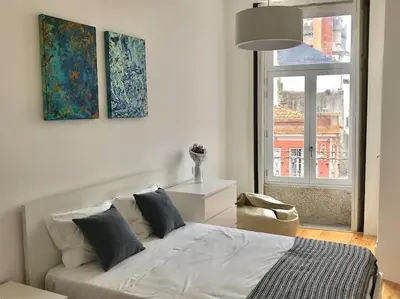 a white bedroom with a bed and a window at Sé Boutique Apartment in Porto