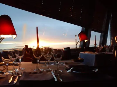 a table with wine glasses and a view of the ocean at Hotel Miradouro in Porto
