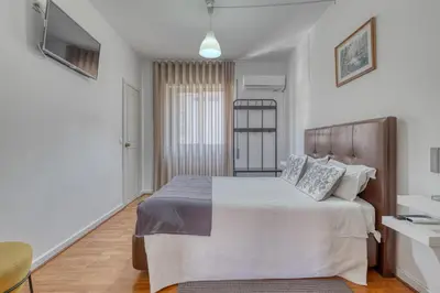 a bedroom with a large bed with white sheets at Hotel Borsalino in Porto