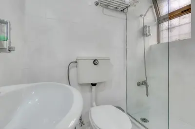 a white bathroom with a toilet and a shower at Hotel Borsalino in Porto