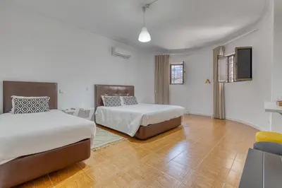 a hotel room with two beds and a television at Hotel Borsalino in Porto