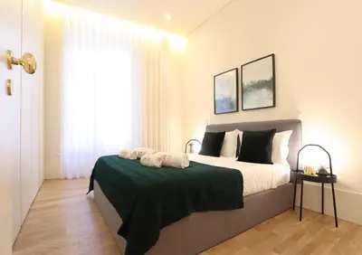a bedroom with a large bed with two towels on it at HM - Ribeira São João 2D in Porto