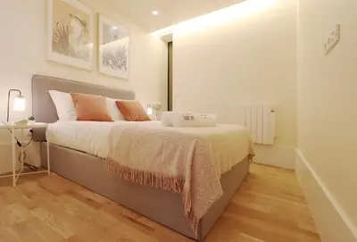 a bedroom with a large bed and a night stand at HM - Ribeira São João 2D in Porto
