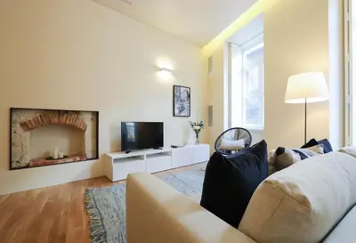 a living room with a couch and a television at HM - Ribeira São João 3F in Porto