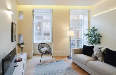 a living room with a couch and a tv at HM - Ribeira São João 3F in Porto