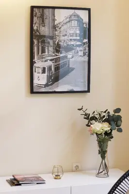 a picture hanging on a wall with a vase of flowers at HM - Ribeira São João 3F in Porto
