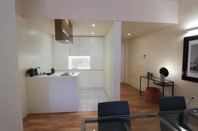 a kitchen with a counter and chairs in a room at HM - Ribeira São João 3F in Porto