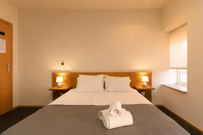 a bedroom with a bed with two towels on it at Peach Hostel & Suites in Porto