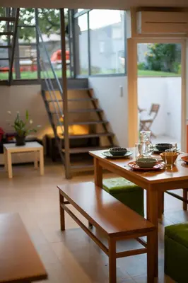 a living room with two tables and a staircase at Peach Hostel & Suites in Porto