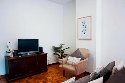 a living room with a tv and a couch and a chair at Casa do Avô in Porto