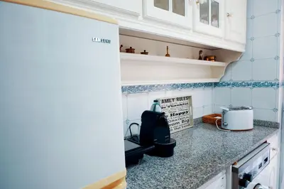 a kitchen with white cabinets and a counter top at Casa do Avô in Porto