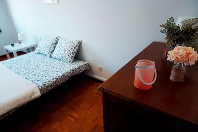 a bedroom with a bed and a table with a vase of flowers at Casa do Avô in Porto
