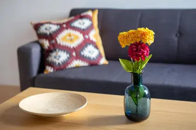 a vase with flowers on a table next to a plate at LovelyStay - Oren Duke's House in Porto