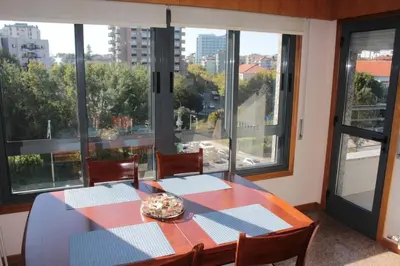 a dining room with a table and some windows at Galizia Flat in Porto