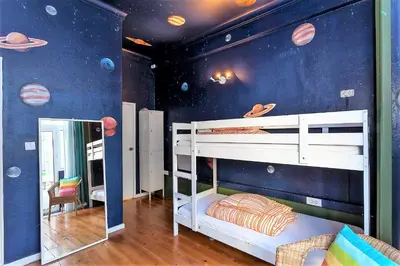 a childs bedroom with a planet themed wall at SUPERNOVA Hostel in Porto