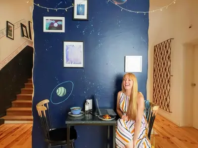 a woman sitting at a table in a room at SUPERNOVA Hostel in Porto