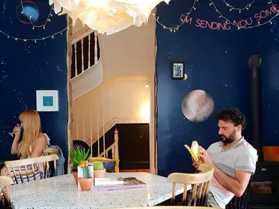 a man sitting at a table in a restaurant at SUPERNOVA Hostel in Porto